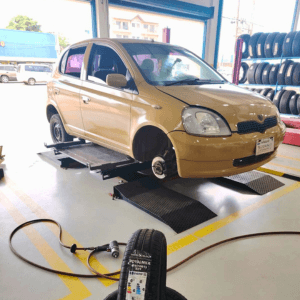 Auto en un puente de montaje de neumáticos